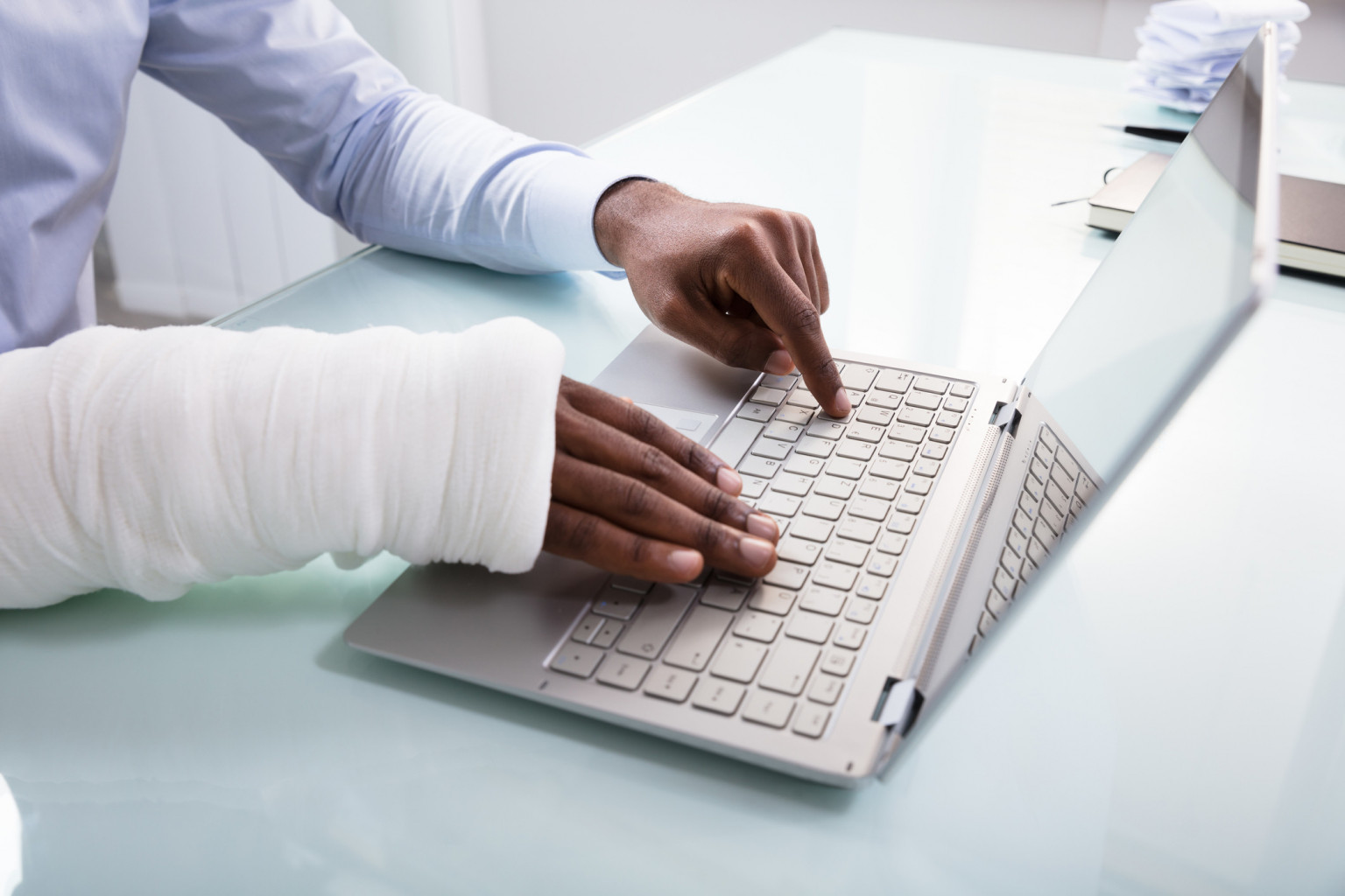 Injury victim typing on laptop.