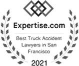 Grayscale badge displaying "Expertise.com Best Truck Accident Lawyers in San Francisco 2021" text with intertwined squares and laurel branches.