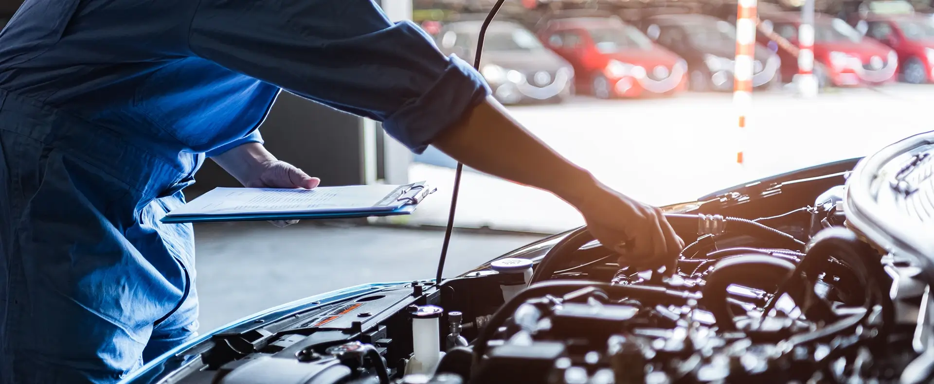 Mechanic inspecting an open car engine bay representing an auto defect product liability claim