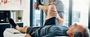 Physical therapist stretching a patient's leg for a severe leg injury or personal injury claim