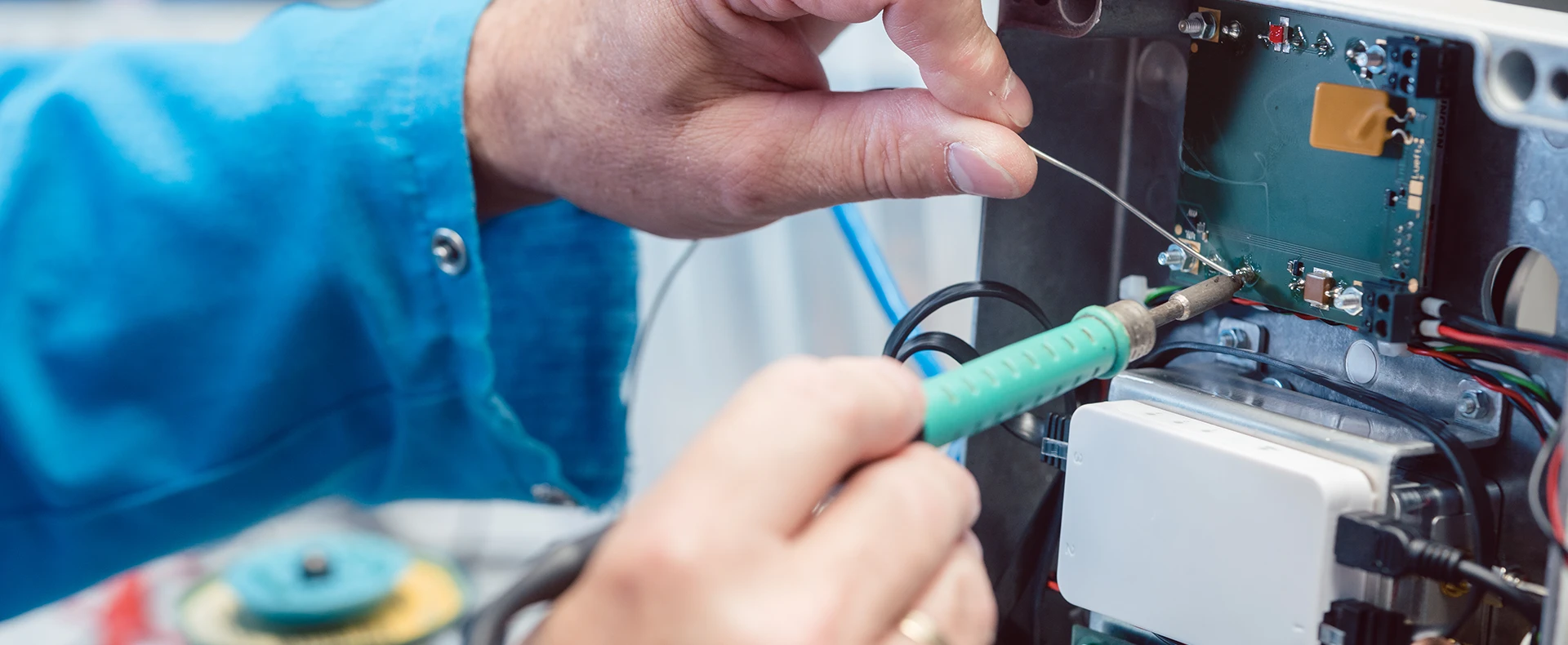 Technician repairing electronic circuit board representing defective product liability
