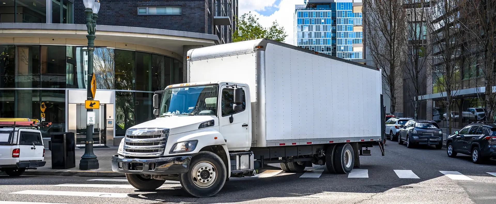 White box truck driving through a city intersection representing a commercial truck accident claim